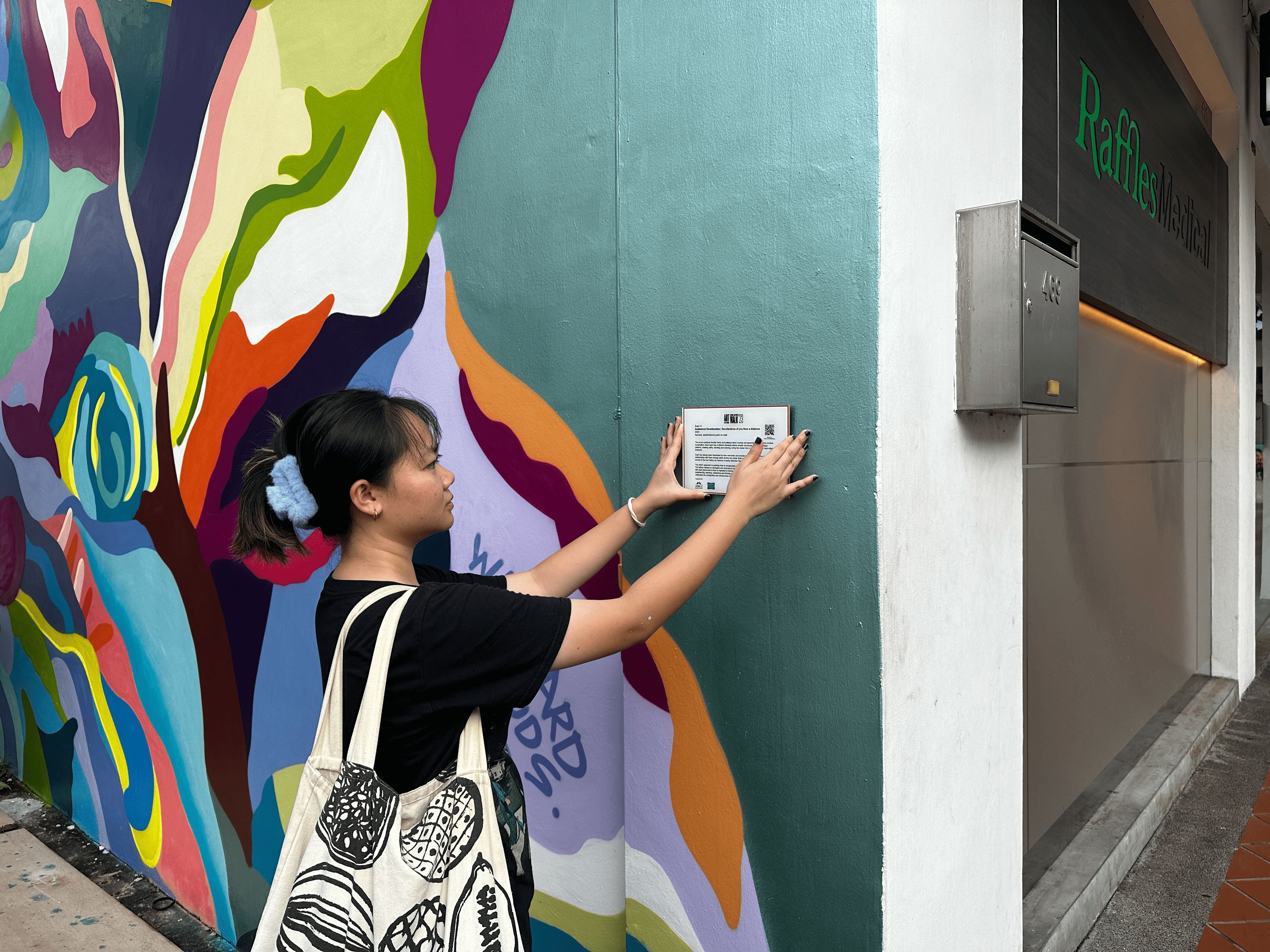 Megan Leow placing an artwork plate for the mural Anatomical Reverberation; Recollections of you from a distance.